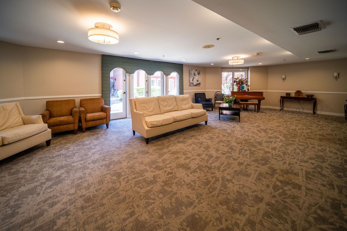 A spacious and comfortable living room with seating arrangements, large windows, and elegant lighting.