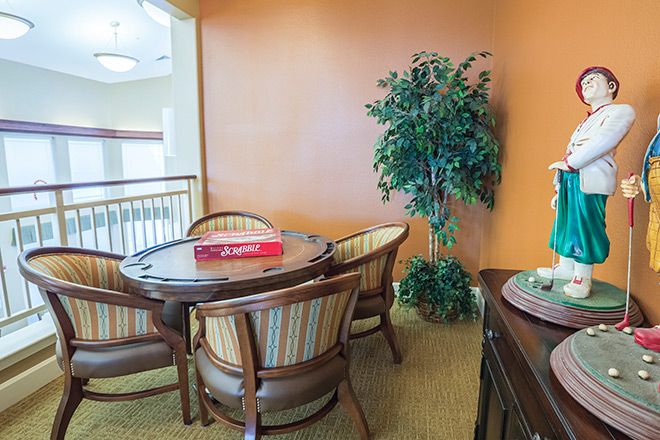 A cozy indoor dining area with a round table, chairs, and a potted plant.