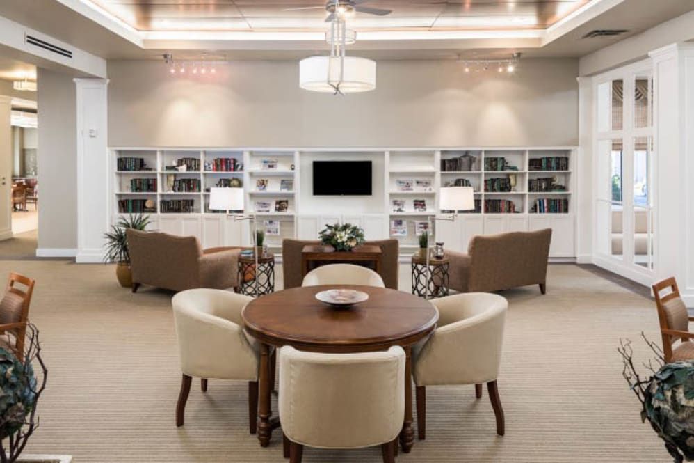 A stylish library with a central seating area and surrounding bookshelves.