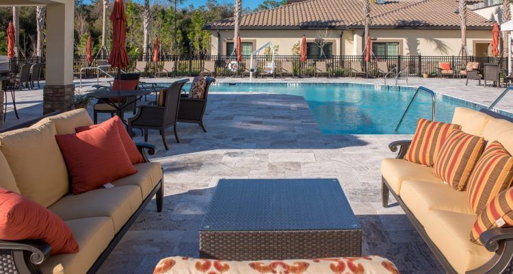 A sunny outdoor pool area with comfortable patio furniture.