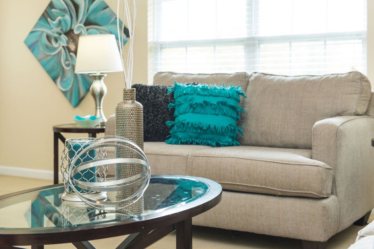 A cozy living room with a beige sofa adorned with turquoise cushions and a decorative coffee table.