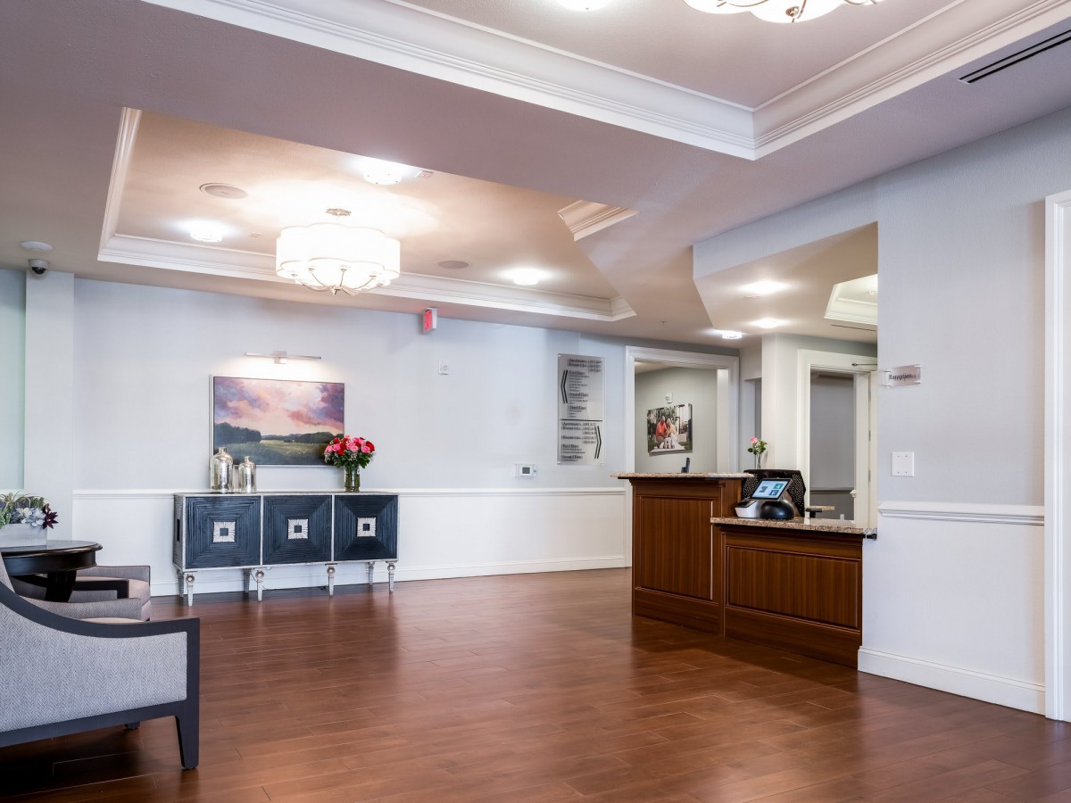 A modern reception area with wooden flooring and elegant lighting.