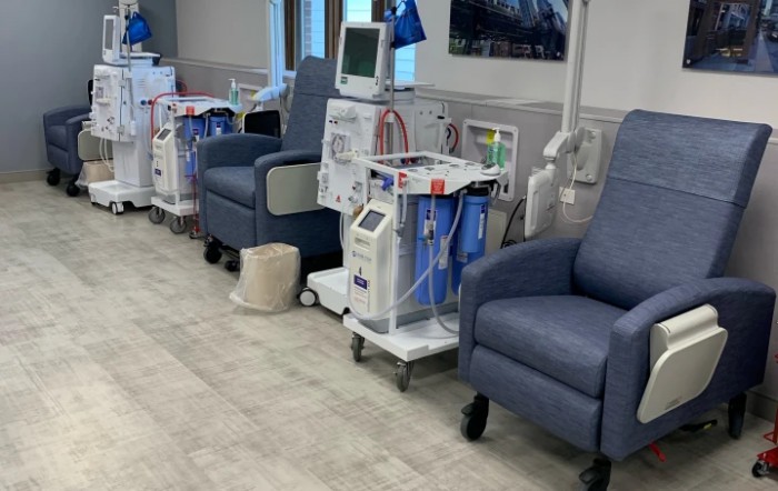 A healthcare facility with dialysis machines and comfortable chairs for patients.