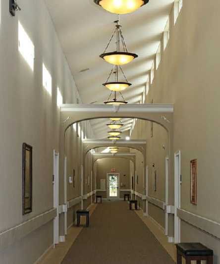 A well-lit hallway with decorative light fixtures and artwork on the walls.