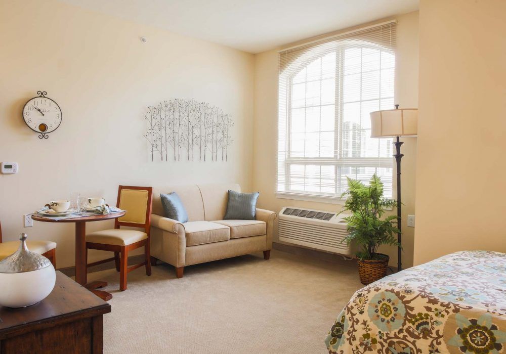 A cozy living space with a sofa, lamp, and large window for natural light.