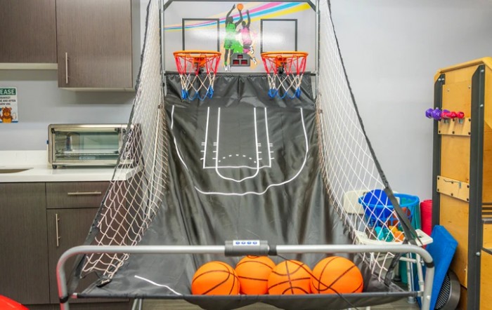An indoor arcade basketball game setup with multiple hoops and basketballs ready to play.