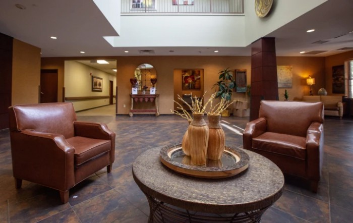 A well-decorated lobby with armchairs and a table centerpiece.