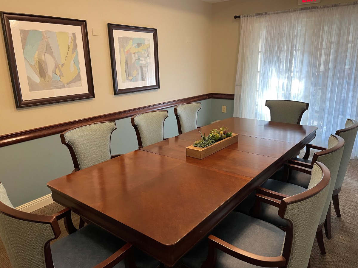 A well-appointed dining room featuring a large wooden table surrounded by chairs and adorned with wall art.