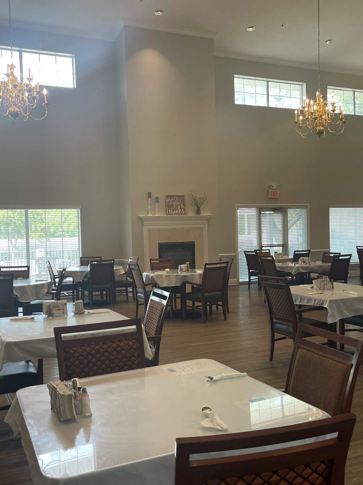 Spacious dining area with elegant chandeliers and a cozy fireplace.