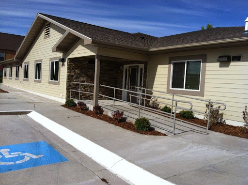 A modern building featuring handicap accessibility with a ramp and landscaped surroundings.