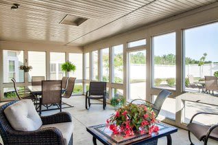 A bright and cozy sunroom with comfortable seating and abundant natural light.
