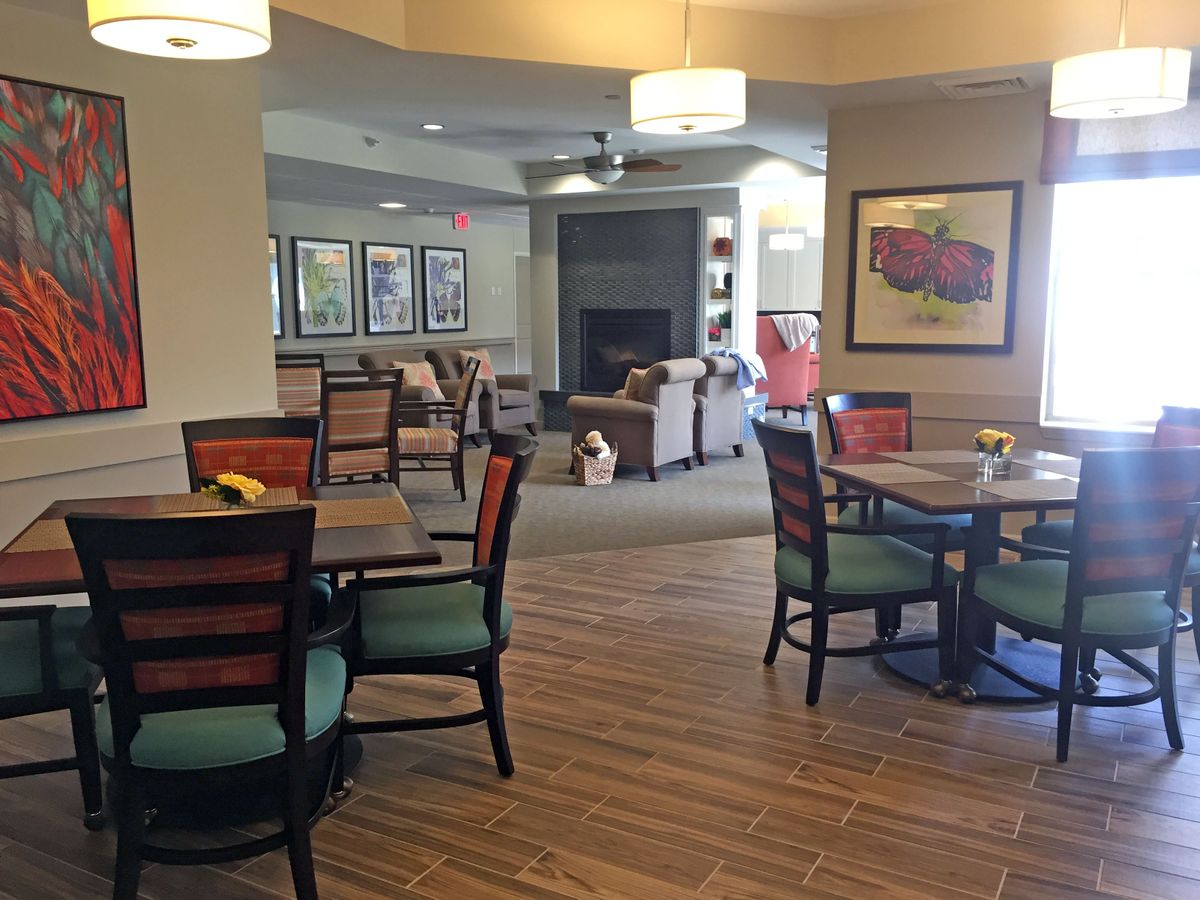 A cozy dining area with tables and chairs, soft lighting, and colorful decor.
