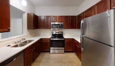 A modern kitchen with stainless steel appliances and wood cabinets.
