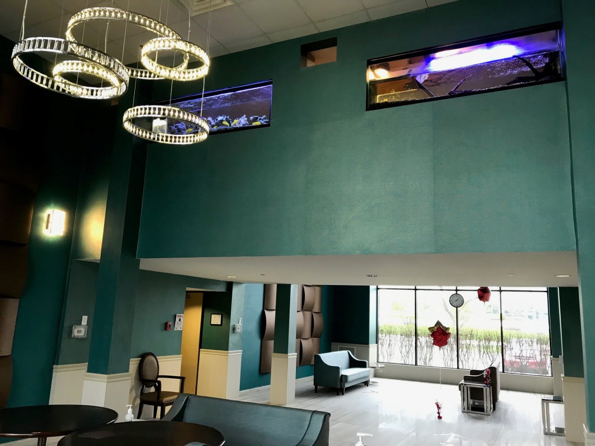 A modern lobby area featuring elegant chandeliers, comfortable seating, and large windows.