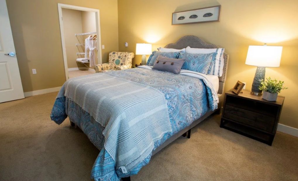 A cozy and modern bedroom with stylish bedding and warm lighting.