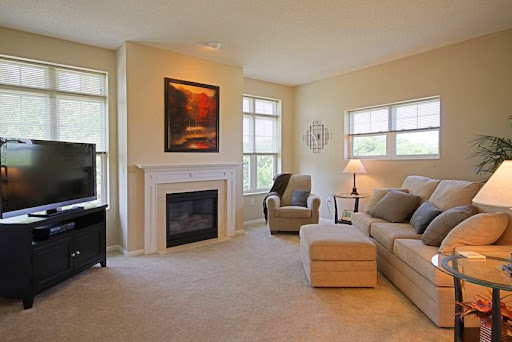 A cozy living room featuring a comfortable sofa, an armchair, and a modern fireplace.