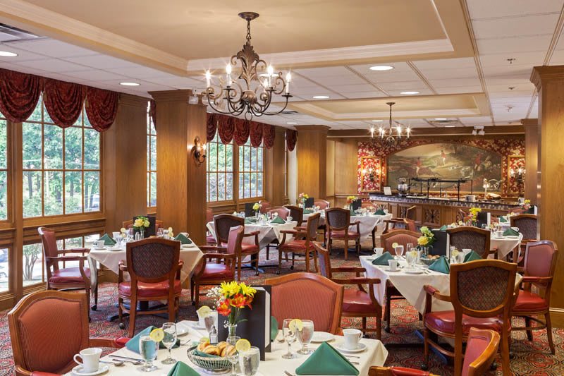 An elegant dining room with neatly arranged tables and chandeliers.