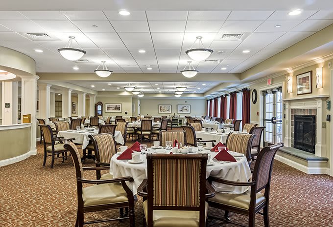 A spacious, elegantly decorated dining room with tables set for a meal.