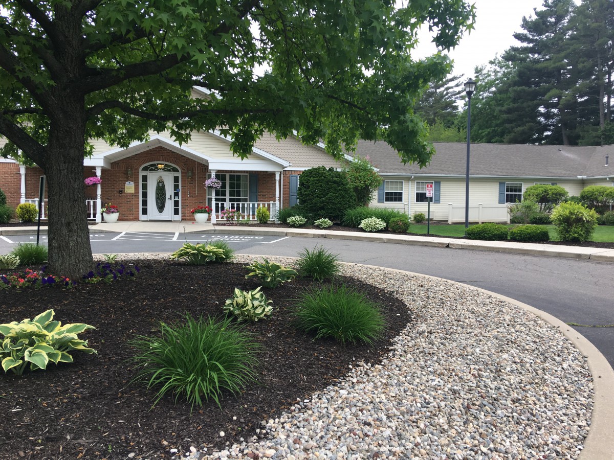 A well-maintained building with landscaped surroundings and a circular driveway.