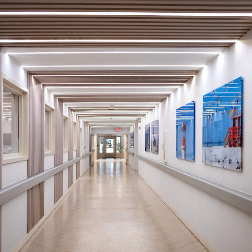 A modern hallway adorned with colorful artwork, featuring sleek lighting and a minimalist design.