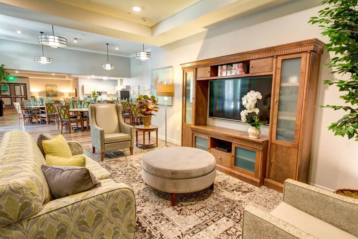 A cozy living room with modern furniture and decor, featuring a television and open-plan layout.