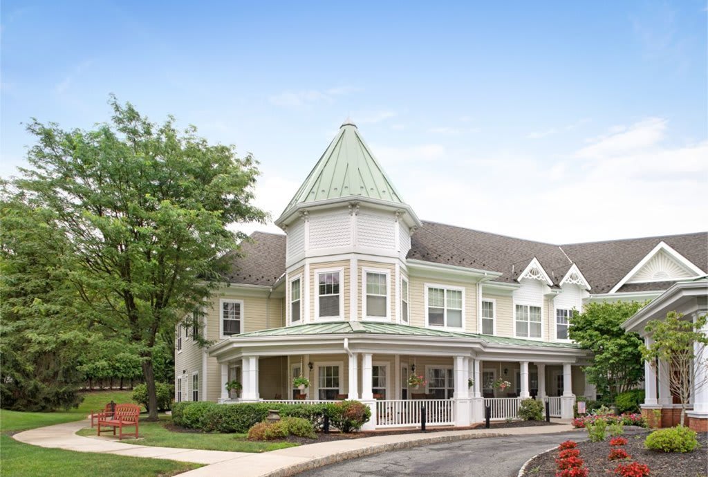 A Victorian-style house with a prominent turret and surrounding greenery.