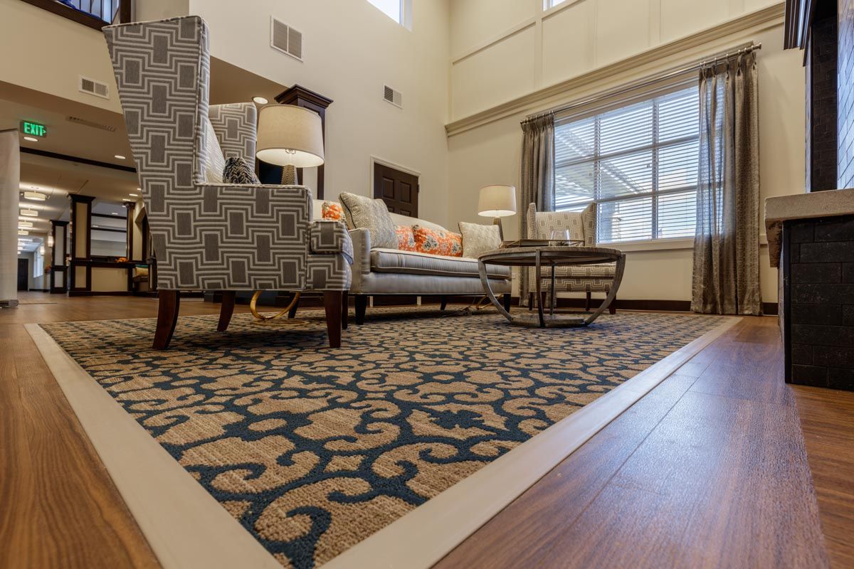 A cozy living room with modern furniture and a decorative rug.