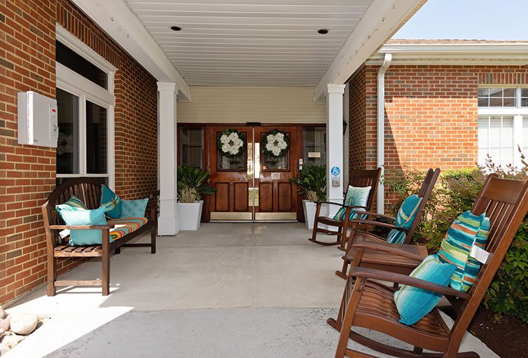 A welcoming entrance with rocking chairs and floral decorations.