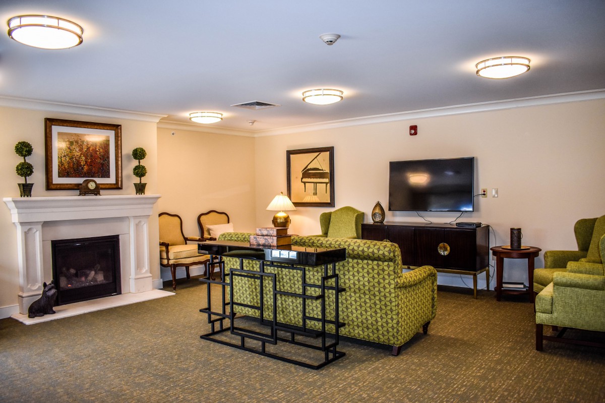 A cozy living room with a fireplace, comfortable seating, and a television.
