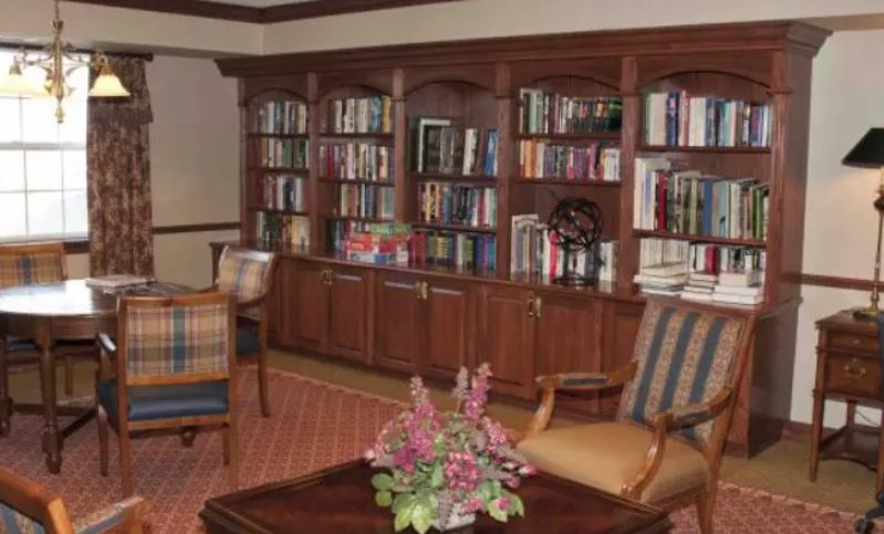 A cozy library with wooden bookshelves and comfortable seating.