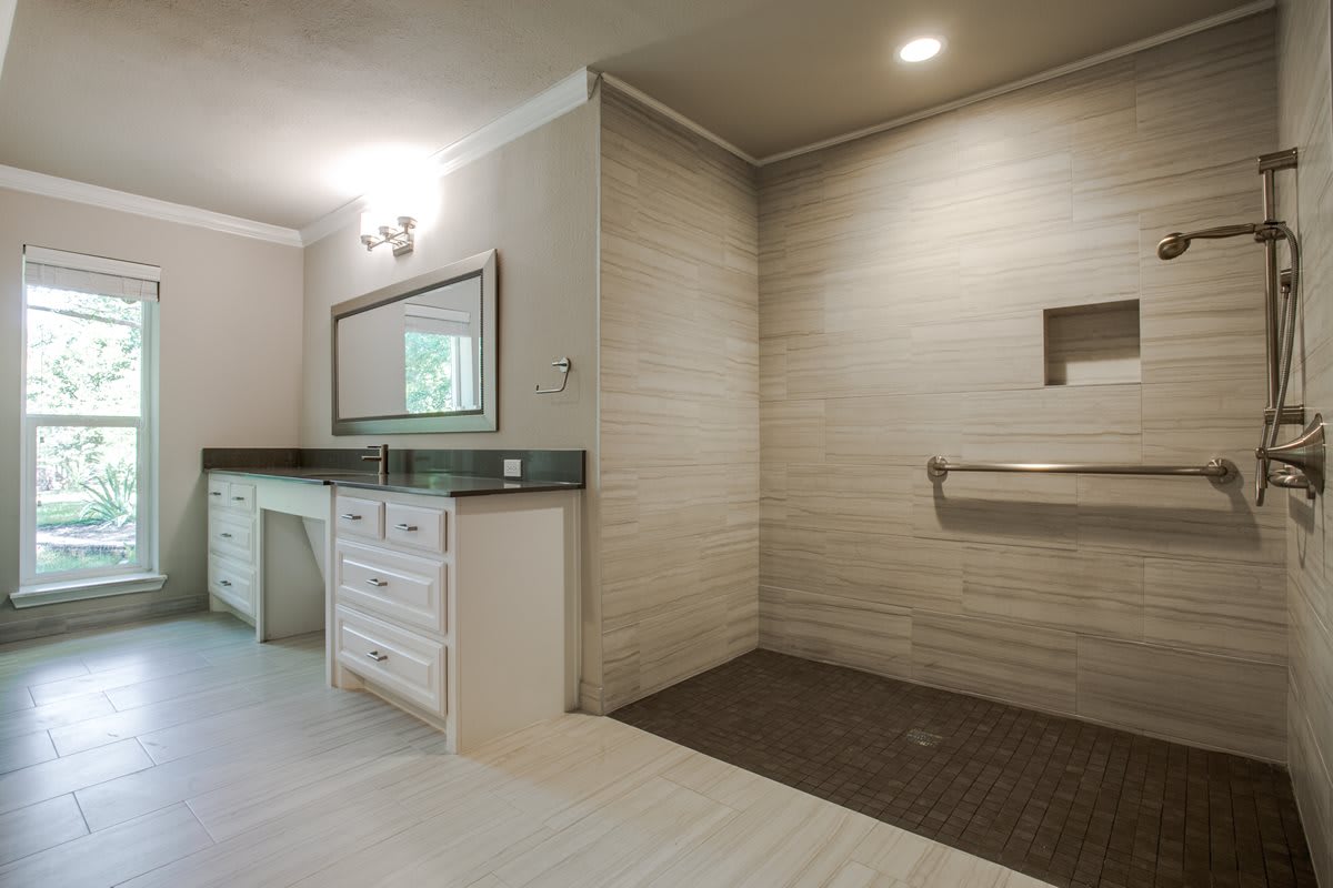 A modern bathroom interior with a spacious shower area and elegant vanity.