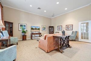 A spacious living room with comfortable seating, artwork on the walls, and decorative elements.