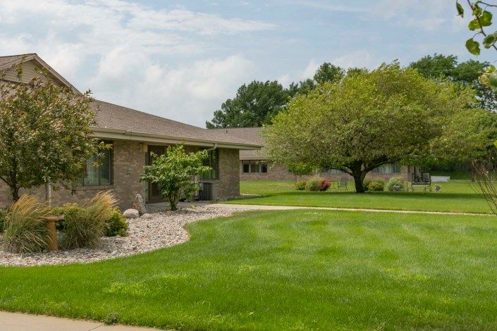 A suburban house with a well-maintained lawn and trees.