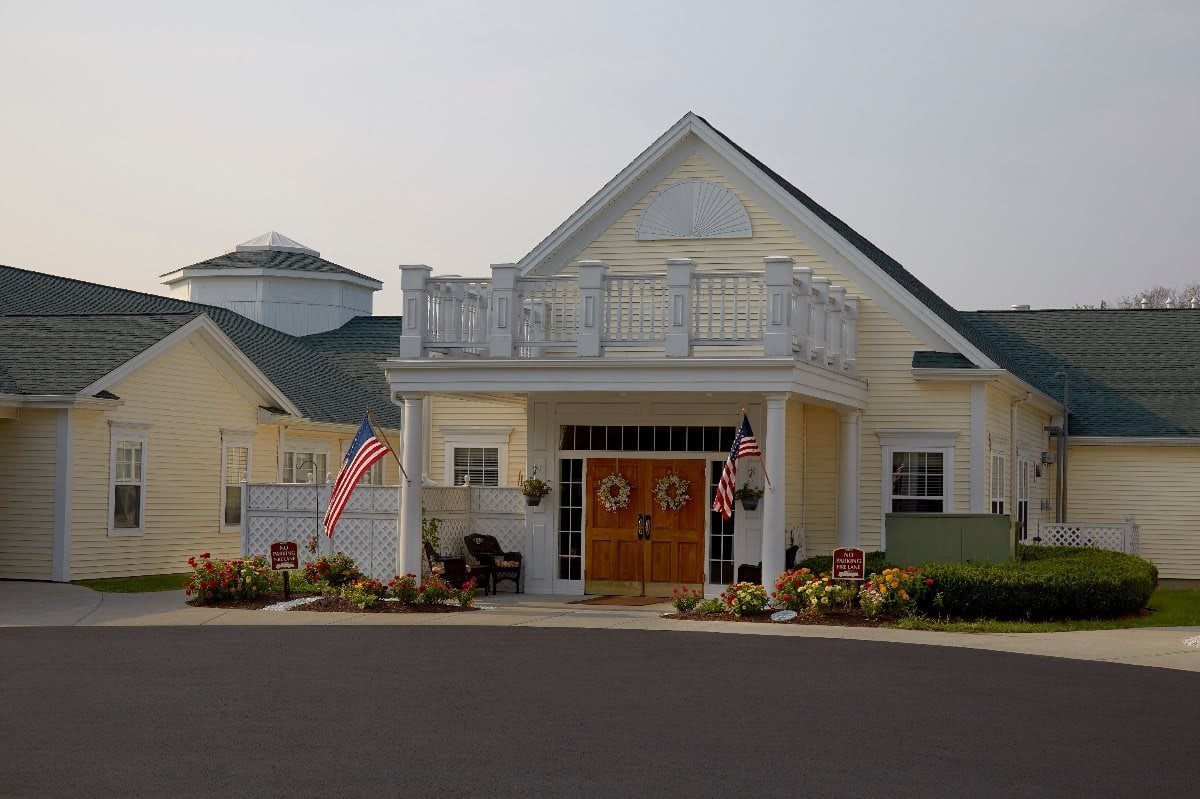 A residential building with decorative flags and landscaped surroundings.