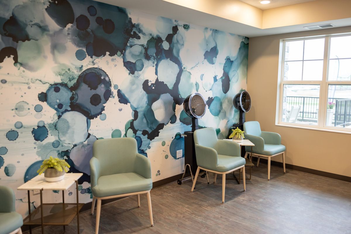 A stylish waiting area featuring modern chairs and abstract wall art.