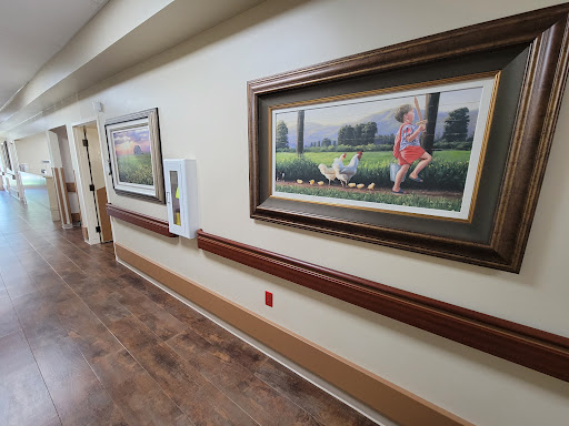 A well-lit hallway featuring framed paintings, enhancing the interior decor.