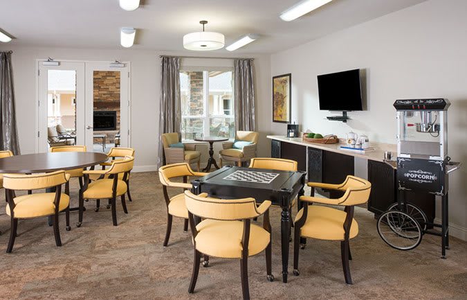 A modern lounge area with comfortable seating, game tables, and a television.