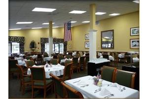 An indoor restaurant dining area with neatly arranged tables and an American flag.