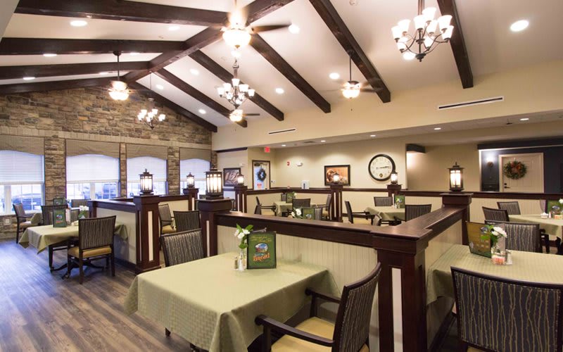 A cozy restaurant interior with elegant lighting and neatly arranged tables and chairs.