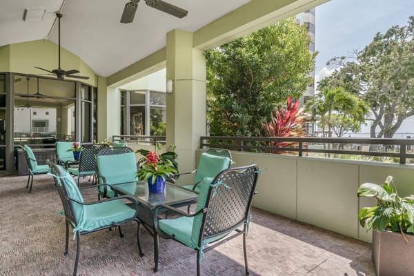 A cozy outdoor patio with comfortable seating and lush greenery.