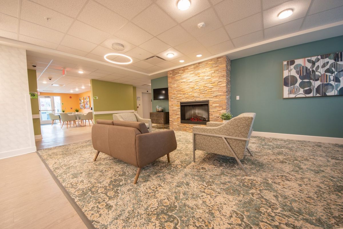 A modern and cozy living room with a stone fireplace and comfortable seating.