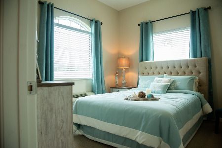A cozy bedroom with teal accents and soft lighting.