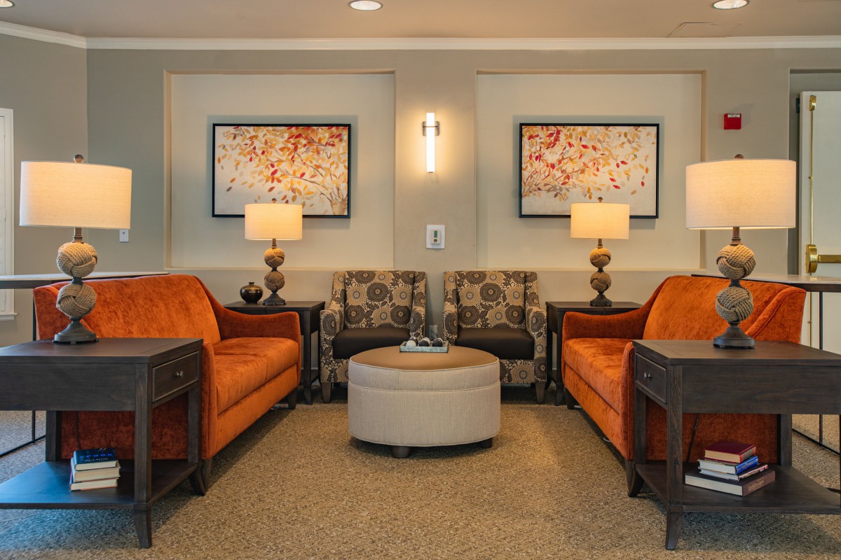 A cozy living room with orange sofas and elegant decor.