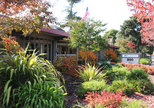 A beautifully landscaped garden showcasing vibrant autumn colors and a welcoming entrance.
