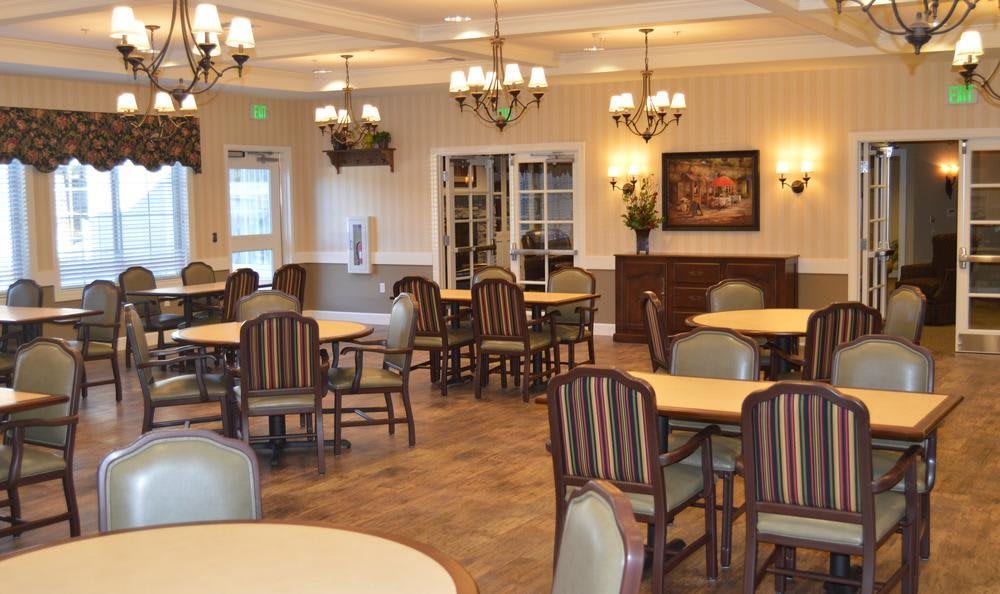 A well-lit dining room with neatly arranged tables and chairs.