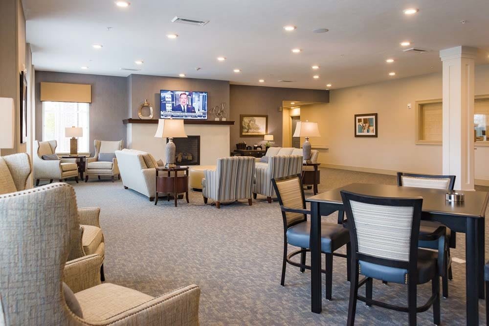 A spacious and well-lit living room with comfortable seating areas and a fireplace.