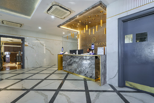 A modern hotel lobby featuring a stylish reception desk with elegant marble and warm lighting.