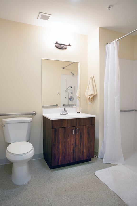 A clean and minimalistic bathroom with a sink, toilet, and shower area.