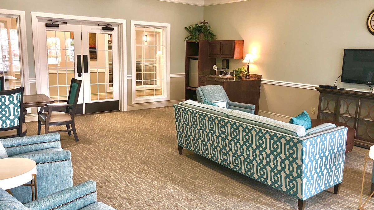 A cozy living room area with comfortable seating, a desk, and soft lighting.