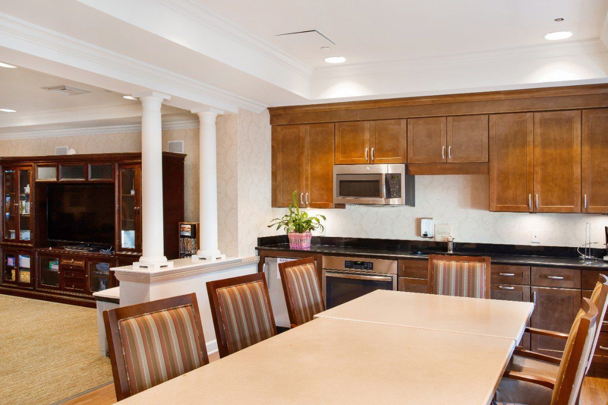 A modern kitchen with wooden cabinets and a dining area featuring a large table and chairs.
